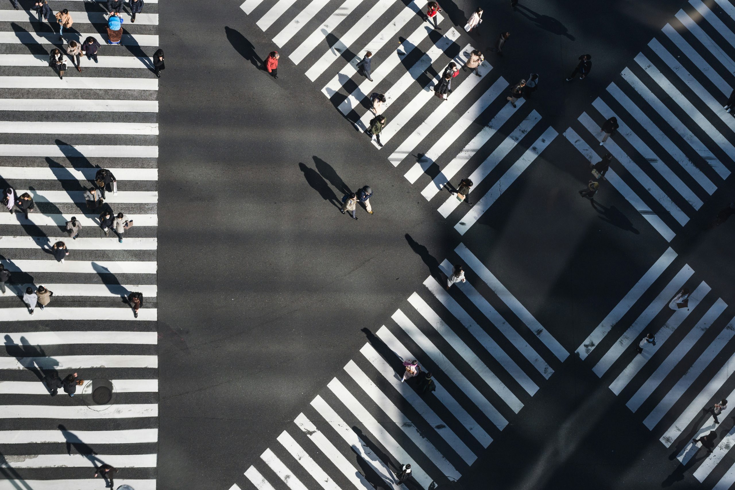 Multiple paths organisations face after VMware licensing changes People crossing multiple zebra crossings, representing organisations choosing different paths after VMware licensing changes.